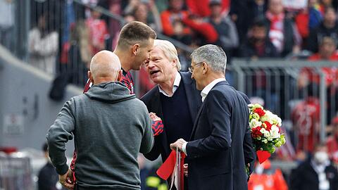 Niklas Süle vom FC Bayern München (l-r), Oliver Kahn und Herbert Hainer, Vereinspräsident vom FC Bayern, stehen auf dem Platz.