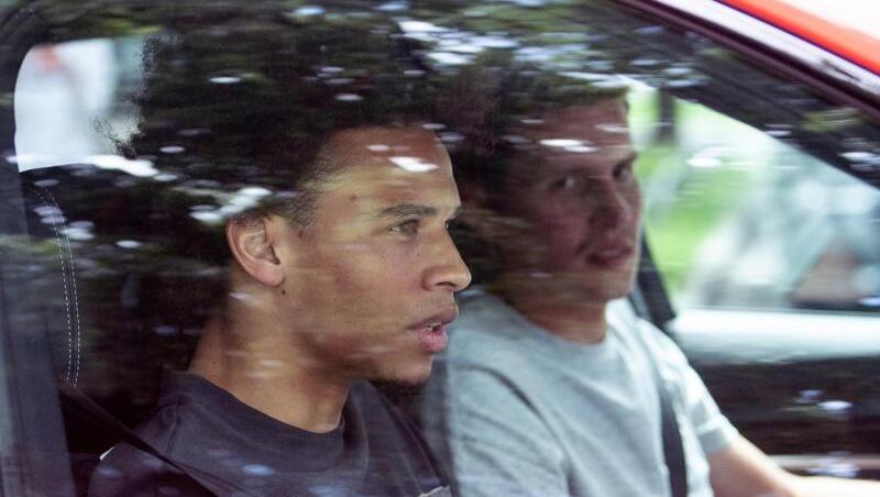FC Bayern-Neuzugang Leroy Sané (l) sitzt beim Verlassen des Trainingsgeländes des FC Bayern an der Säbener Straße auf dem Beifahrersitz eines Autos. Foto: Matthias Balk/dpa/Archiv FC Bayern-Neuzugang Leroy Sané (l) sitzt beim Verlassen des Trainingsgeländes des FC Bayern an der Säbener Straße auf dem Beifahrersitz eines Autos. Foto: Matthias Balk/dpa/Archiv
