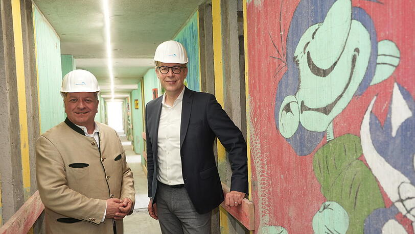 Bauminister Christian Bernreiter (l.), Bildungsminister Markus Blume (beide CSU) und &bdquo;Gaston&ldquo; in den entkernten Fluren des Haus 12.