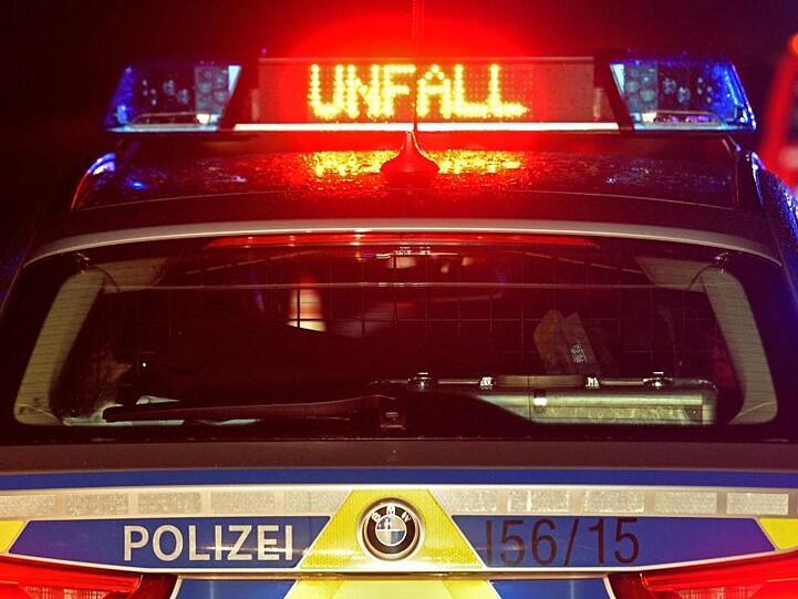 Auf der A8 spiegeln sich während einer Unfallaufnahme das Blaulicht und der LED- Schriftzug "Unfall" auf dem nassen Dach eines Polizestreifenwagens. Foto: Stefan Puchner/dpa/Symbolbild