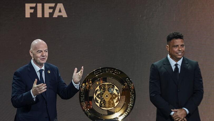 FIFA-Präsident Gianni Infantino (l) und Brasiliens früherer Starstürmer Ronaldo präsentierten bei der Auslosung der Gruppen für die Club-WM 2025 den Siegerpokal. FIFA-Präsident Gianni Infantino (l) und Brasiliens früherer Starstürmer Ronaldo präsentierten bei der Auslosung der Gruppen für die Club-WM 2025 den Siegerpokal.