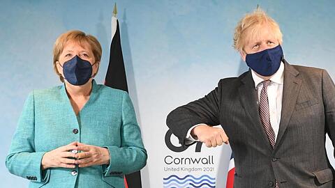 Der britische Premierminister Boris Johnson gestikuliert bei dem Fotoshooting mit Angela Merkel.