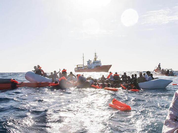 Flüchtlinge, die auf Booten von Libyen aus nach Italien übersetzen wollten, werden während eines Rettungseinsatzes vor der nordafrikanischen Küste geborgen.