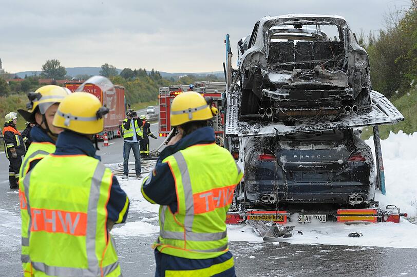 Völlig verbrannt und voller Lösch-Schaum: Auf der A9 bei Bayreuth ist ein Autotransporter in Flammen aufgegangen. Geladen hatte der Lastzug hochwertige Porsche Cayenne und Panamera. Die Bilder.