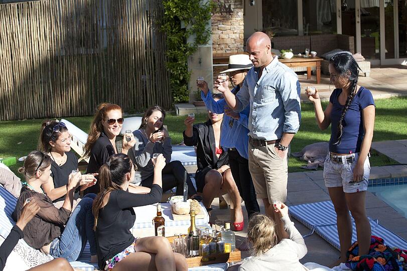 Bachelor Christian und die Ladies stoßen mit einem Glas Likör im Garten der Villa an.