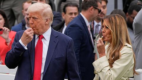 Präsident Donald Trump und Melania Trump blasen während des White House Easter Egg Roll in Trillerpfeifen.