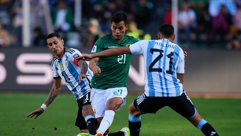 Boliviens Hector Cuellar in Aktion gegen die Argentinier Angel Di Maria (l) und Nahuel Molina (21).
