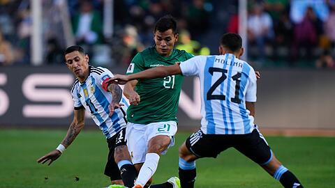 Boliviens Hector Cuellar in Aktion gegen die Argentinier Angel Di Maria (l) und Nahuel Molina (21).