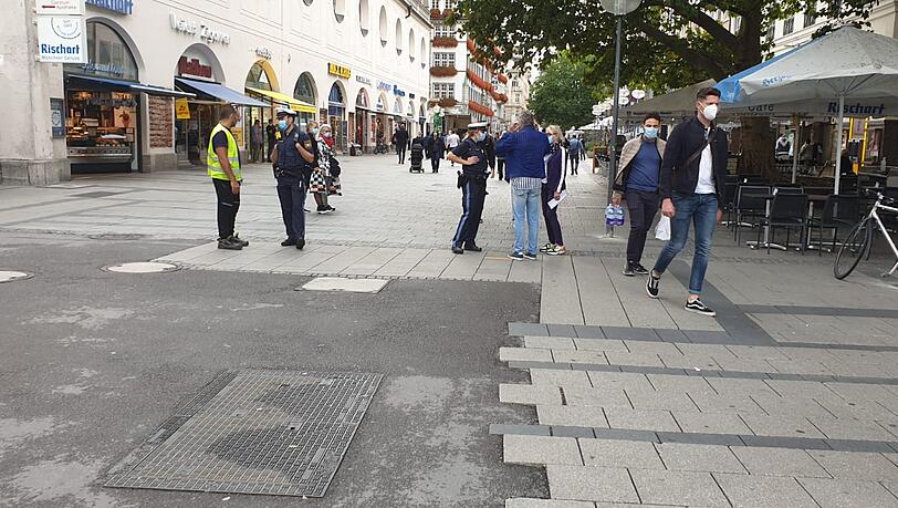 Polizisten kontrollieren die Maskenpflicht in der Fußgängerzone. Polizisten kontrollieren die Maskenpflicht in der Fußgängerzone.