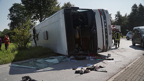 Rettungskräfte stehen am 23.08.2017 an der Bundesstraße 65 bei Bohmte (Niedersachsen) an einem umgestürtzten Reisebus.