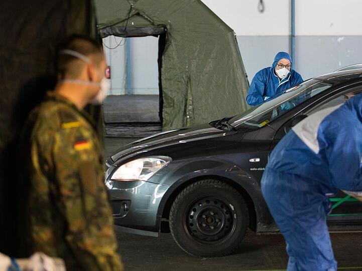 Ein Arzt nimmt bei einer von der Bundeswehr organisierten Drive-In-Teststation in Saarbrücken Abstriche.