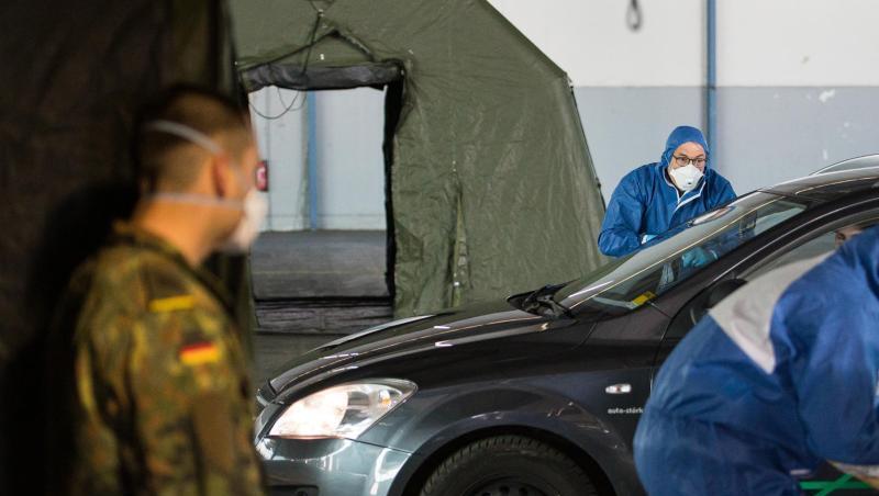 Ein Arzt nimmt bei einer von der Bundeswehr organisierten Drive-In-Teststation in Saarbrücken Abstriche. Ein Arzt nimmt bei einer von der Bundeswehr organisierten Drive-In-Teststation in Saarbrücken Abstriche.