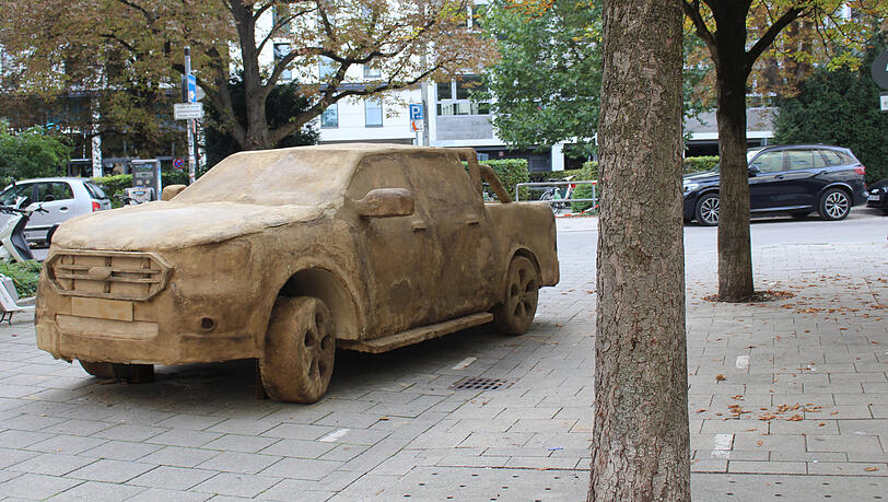 Die Kunst und im Hintergrund ein Original: Drei solcher Moder-SUVs stehen nun ein Jahr lang in München und verrotten immer mehr. Sie sollen eine Diskussion über den Autoverkehr in der Stadt auslösen Die Kunst und im Hintergrund ein Original: Drei solcher Moder-SUVs stehen nun ein Jahr lang in München und verrotten immer mehr. Sie sollen eine Diskussion über den Autoverkehr in der Stadt auslösen