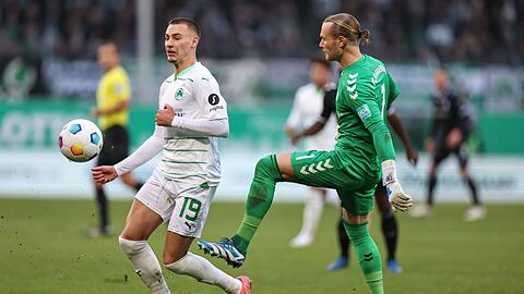 Der Fürther Tim Lemperle (l) kämpft mit Torwart Dominik Reimann aus Magdeburg um den Ball.