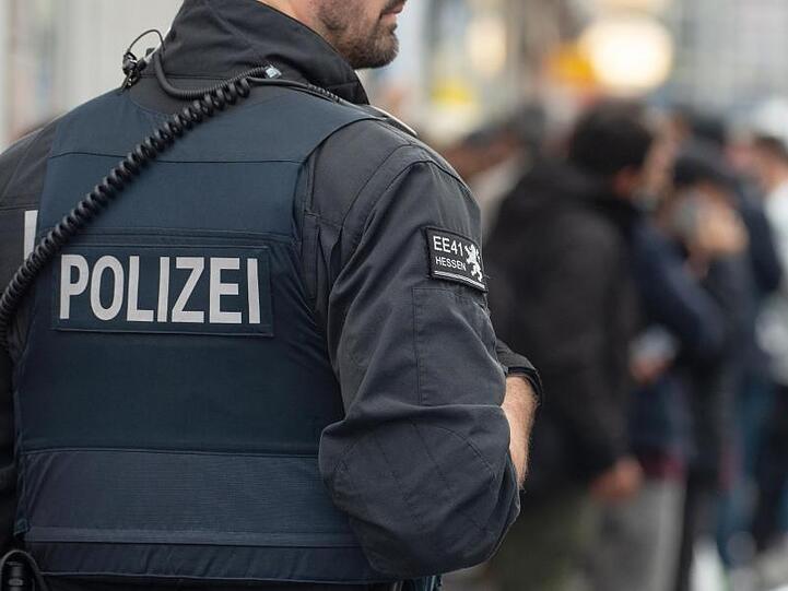 Ein Polizist kontrolliert Personen in der Innenstadt. Foto: Swen Pförtner/dpa/Symbolbild