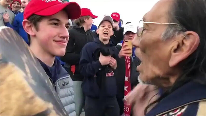 Schüler einer katholischen Highschool stellen sich einem amerikanischen Ureinwohner in den Weg und verspotten ihn.