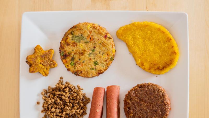 Verschiedene vegane und vegetarische Fleischersatzprodukte liegen auf einem Teller. Verschiedene vegane und vegetarische Fleischersatzprodukte liegen auf einem Teller.