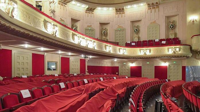 Abgedeckt sind leere Sitzplätze in einem Theater.