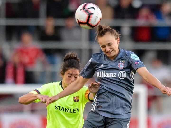 Marta Torrejon von Barcelona (l) und Lina Magull vom FC Bayern München während des Hinspiels im Kopfballduell um den Ball. Foto: Matthias Balk