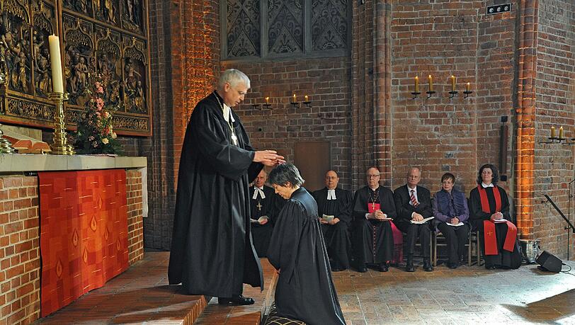 Bayerns Landesbischof Johannes Friedrich (l) segnet am Samstag (26.03.2011) die Landesbischöfin a.D. Margot Käßmann während des Festgottesdienstes in der Marktkirche in Hannover. Bayerns Landesbischof Johannes Friedrich (l) segnet am Samstag (26.03.2011) die Landesbischöfin a.D. Margot Käßmann während des Festgottesdienstes in der Marktkirche in Hannover.