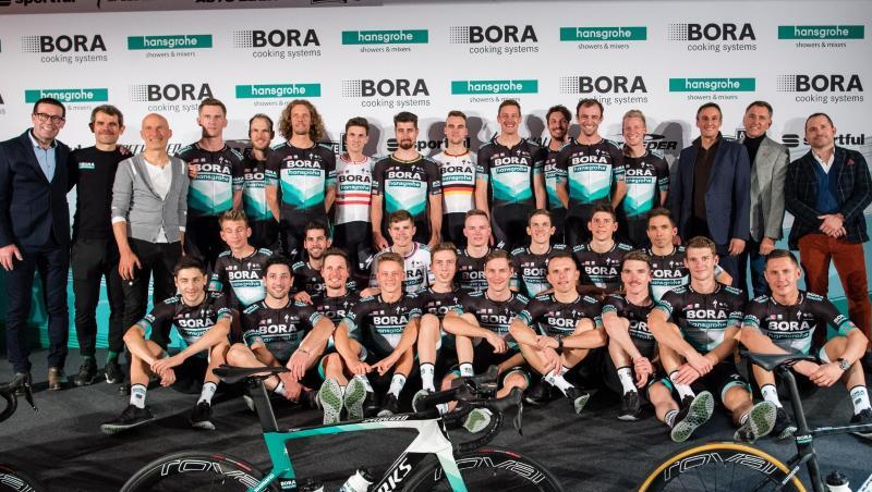 Ralph Denk (hinten, 2.v.l.), Teammanager des Radsportteams von Bora-hansgrohe, und das Team stellen sich bei der Vorstellung des Radsportteams für das Jahr 2020 auf der Bühne zum Gruppenfoto auf. Foto: Matthias Balk/dpa/Archivbild