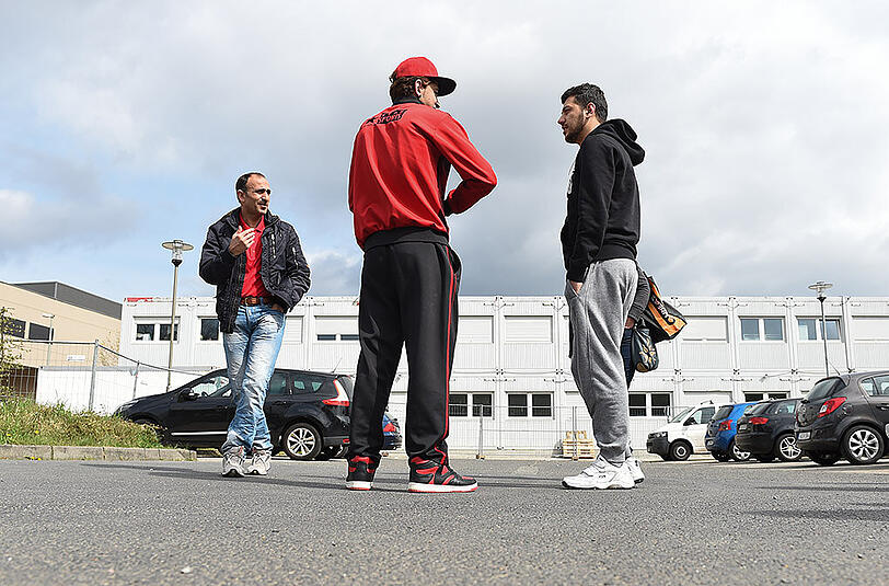 Syrische Flüchtlinge stehen vor einer Flüchtlingsunterkunft in Hofheim.