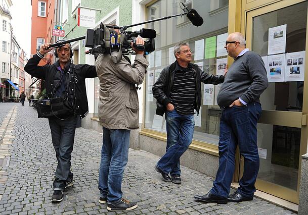 Mit seiner Reportage-Serie "Gernstl unterwegs" bereist Franz Xaver Gernstl (2. v. r.) über 40 Jahre lang die ganze Welt - hier etwa im Jahr 2011 in Regensburg im Interview mit einem Immobilienmakler (rechts).