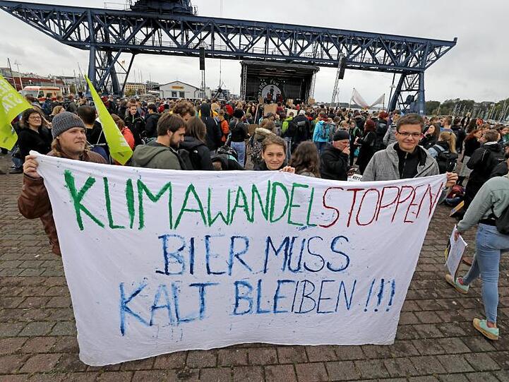 Diese Demonstranten in Rostock haben auch ein Plakat zur Demo mitgebracht.