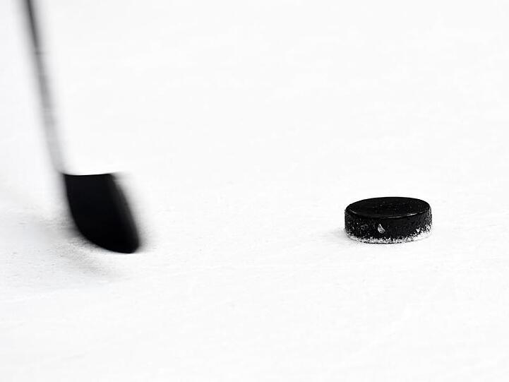 Ein Puck und ein Eishockeyschläger. Foto: Tobias Hase/dpa/Archivbild