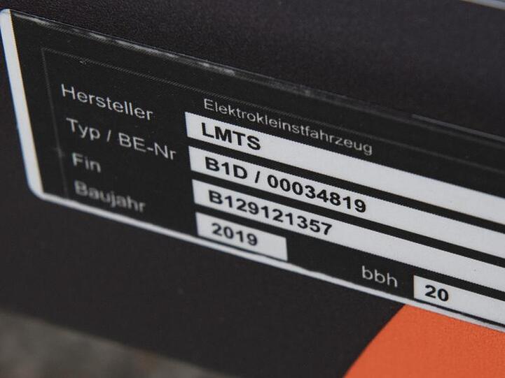 Auf dem Rahmen eines E-Tretrollers ist die Betriebserlaubnis des Kraftfahrtbundesamtes zu sehen. Damit sind die Tretroller für den Straßenverkehr zugelassen.