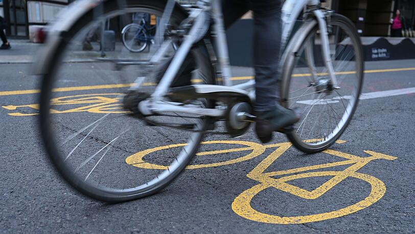 Eine Fahrradfahrerin fährt auf aufeinem Fahrradweg.