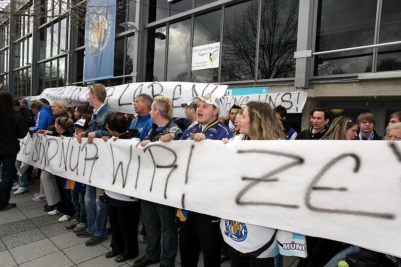"Rettet München", "Kämpft um unser Leben" und "Der EHC sind nur wir": Das steht auf den Bannern der Fans des EHC. Vor der Olympia-Eishalle demonstrieren sie gegen das Aus des Münchner Eishockey-Vereins.