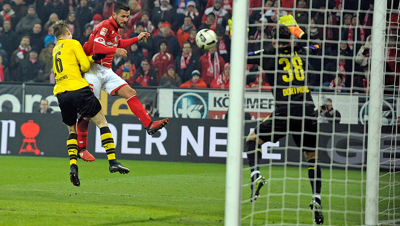 Der Mainzer Danny Latza köpft gegen den Dortmunder Torwart Roman Buerki das Tor zum 1:1. Links: Lukasz Piszczek. Der Mainzer Danny Latza köpft gegen den Dortmunder Torwart Roman Buerki das Tor zum 1:1. Links: Lukasz Piszczek.
