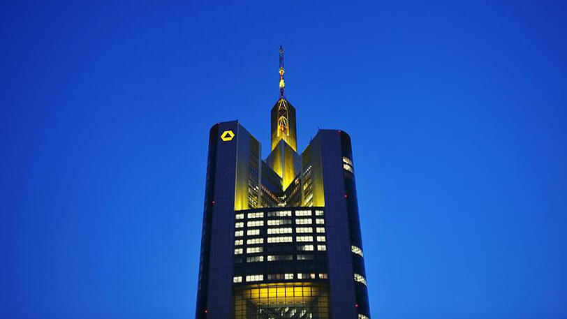 Die Zentrale der Commerzbank in Frankfurt am Main leuchtet im Abendlicht.