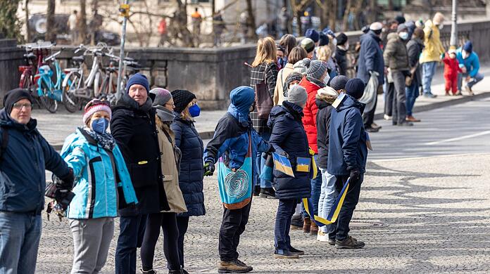 Teilnehmer einer Demonstration zum Ukraine-Konflikt bilden eine Menschenkette.