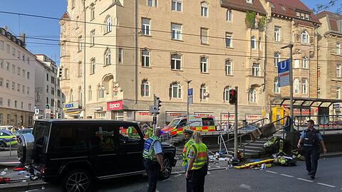 Am frühen Abend fährt ein Fahrzeug in eine Menschengruppe an einer Bahnhaltestelle.