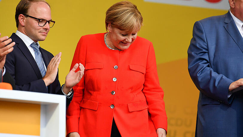 Bundeskanzlerin Angela Merkel inspiziert nach einem Tomatenwurf in Heidelberg ihre Jacke. Bundeskanzlerin Angela Merkel inspiziert nach einem Tomatenwurf in Heidelberg ihre Jacke.