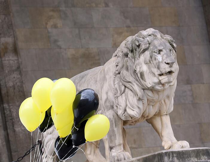 Schwarze und gelbe Luftballons - die Farben Münchens - neben dem Löwen vor der Feldherrenhalle.