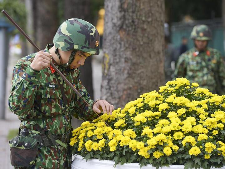 Suche nach Verdächtigem: Ein Soldat inspiziert in Hanoi einen Blumenkübel.