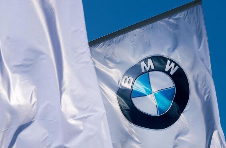 Wehende Fahnen mit dem Logo von BMW. Foto: Alexander Heinl/dpa/Archivbild