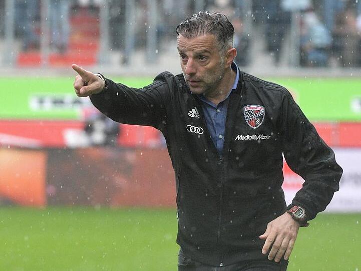 Trainer Thomas Oral (Ingolstadt) steht im Regen und gestikuliert. Foto: Stefan Puchner/Archivbild