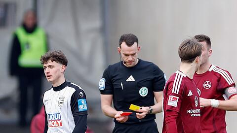 Ulms Maurice Krattenmacher (l) sieht Gelb-Rot nach einer Schwalbe im Strafraum.