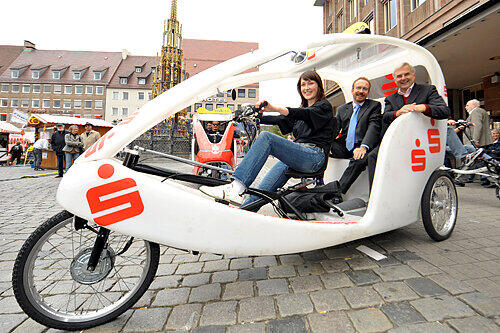 Umweltfreundlich, schnell und überaus bequem: Fahrerin Olga mit Otfried Bürger (li.), PR-Referent der Stadtsparkasse, und Umweltreferent Peter Pluschke beim Probesitzen im &bdquo;Velotaxi&ldquo;.