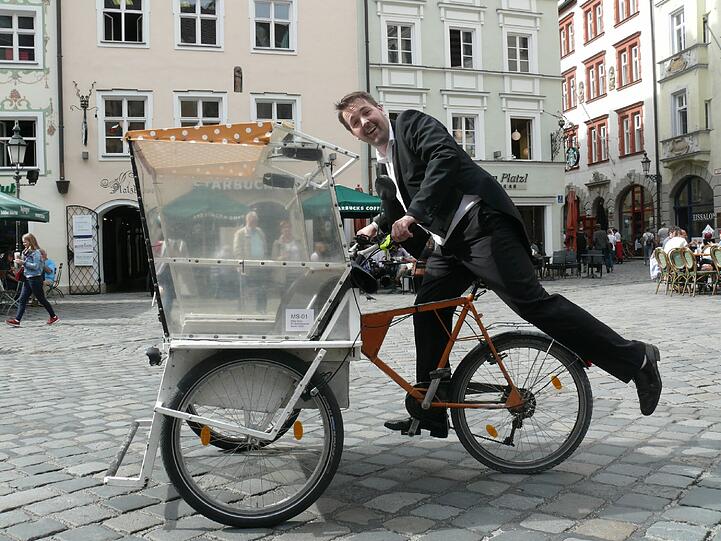André Hartmann als kabarettistischer Rikschafahrer in voller Fahrt.