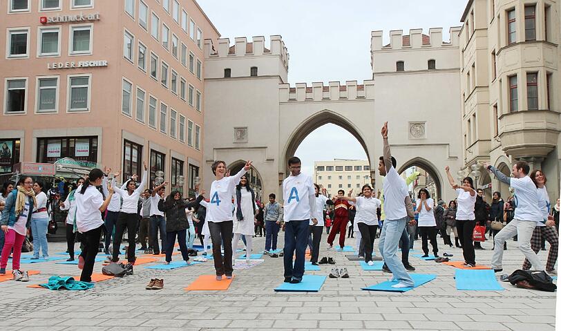 Hopsen und Dehnen in der Fußgängerzone: Am Stachus haben sich Yoga-Fans zu einem Flashmob unter freiem Himmel verabredet. Die Bilder.
