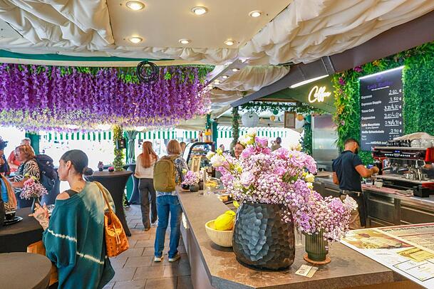 Rund 3000 lila Papierblumen hängen in der neuen Eis & Kaffeebar über den Stehtischen von der Decke.
