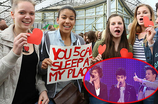 Die Teeniestars von "One Direction" spielen am Freitag in der Olympiahalle. Jubelnde Fans warten im Regen vor der Olympiahalle.