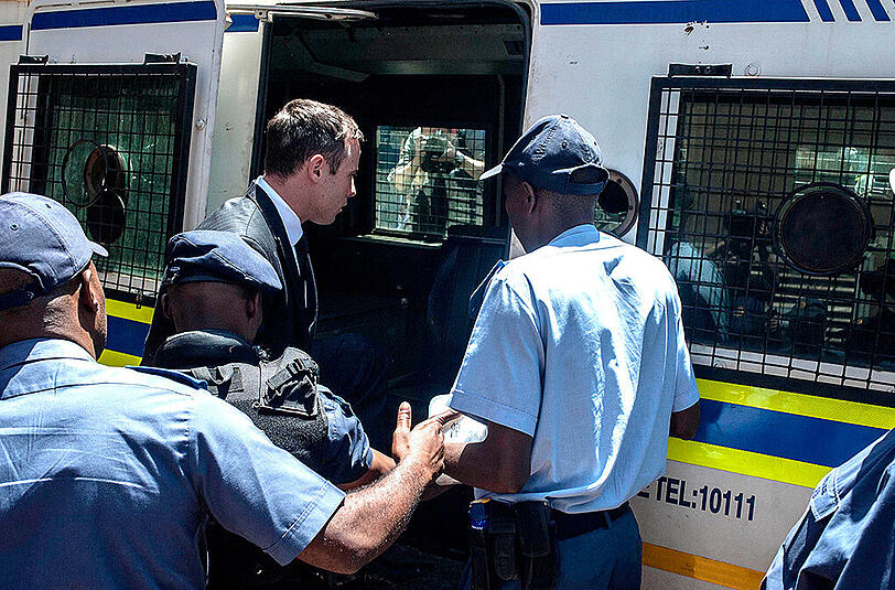 Oscar Pistorius wird nach der Strafmaß-Verlesung von Polizisten abgeführt.