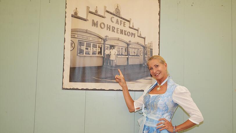 Die Festwirtin zeigt auf ein Foto im Zelt: So sah das "Café Mohrenkopf" 1950 aus. Es ist laut Wiemes das älteste Café-Zelt auf der Wiesn. Die Festwirtin zeigt auf ein Foto im Zelt: So sah das "Café Mohrenkopf" 1950 aus. Es ist laut Wiemes das älteste Café-Zelt auf der Wiesn.