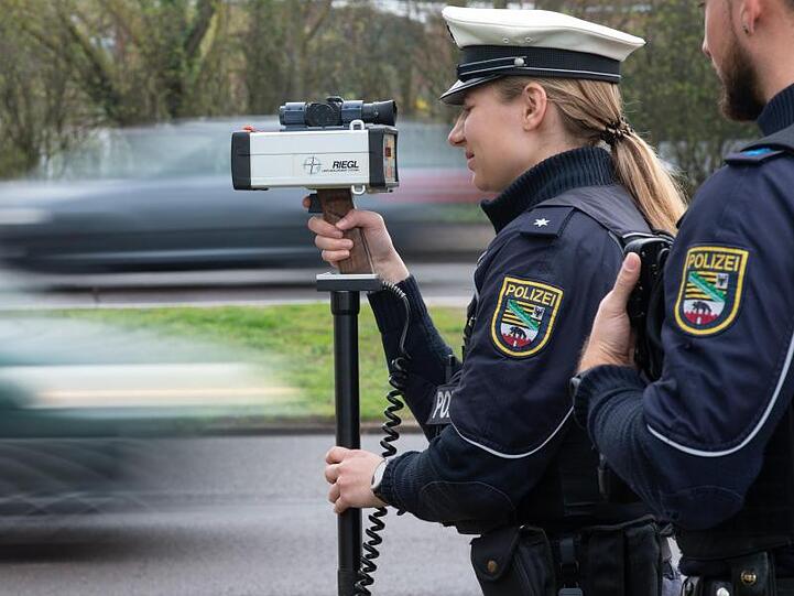 Polizisten stehen an einer Straße in Magdeburg und messen die Geschwindigkeit der vorbeifahrenden Verkehrsteilnehmer.